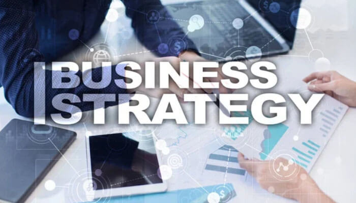 Business professionals collaborating on a Business Strategy with laptops, charts, and graphs on a desk