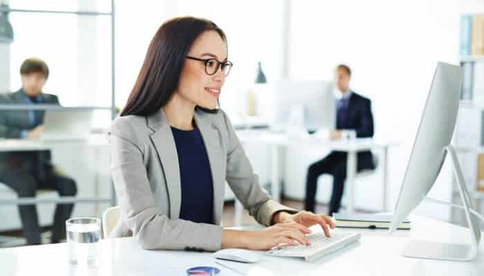 Businesswoman troubleshooting high CPU usage on her computer caused by Windows Modules Installer Worker in a modern office environment