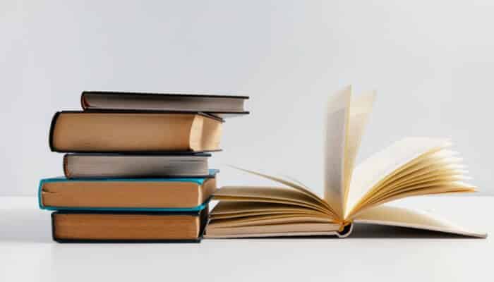 A stack of hardcover books beside an open personalised notebook, showcasing custom stationery perfect for journaling, studying, or professional use