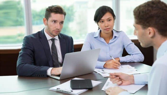 Lawyers meeting with a client to discuss workers’ compensation claims denied and strategies for appealing workplace injury cases.