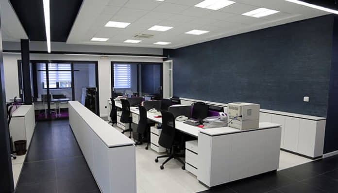Modern office setup with Commercial Lighting for Workspaces featuring LED ceiling panels, ergonomic desks, and bright task-oriented illumination.