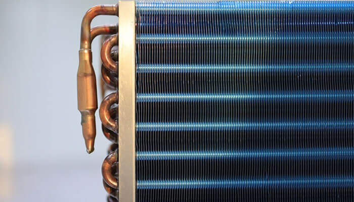 Close-up of a quality used plate exchanger showing metal plates and copper tubing designed for efficient industrial heat transfer