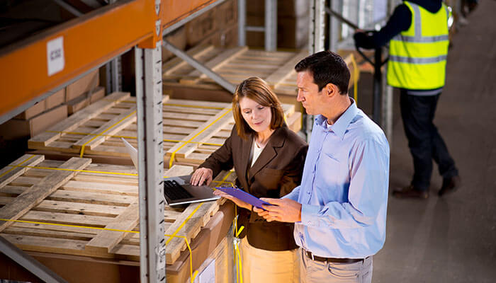 Business team reviewing inventory in a warehouse, highlighting operational challenges and mistakes most startups make in managing assets and processes.