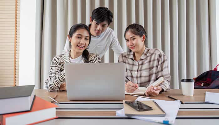 Students collaborating on a laptop during an online class, showcasing how tech tools in remote teaching support teamwork and digital learning.