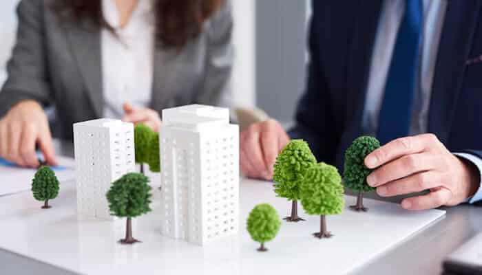 Professionals discussing sustainable city development models representing collaborative strategies in Urban Project Planning.