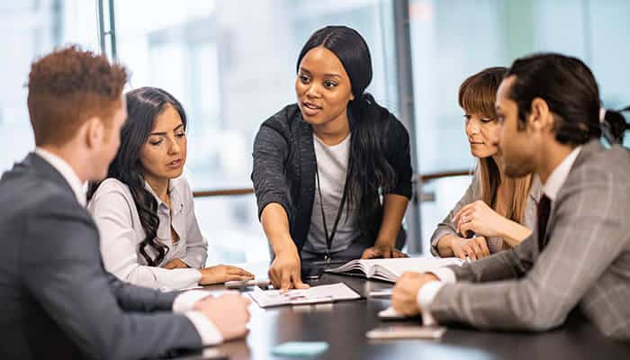 A team discussing strategies in a meeting room, illustrating how managing organizational change while adopting enterprise SEO services improves collaboration and results.