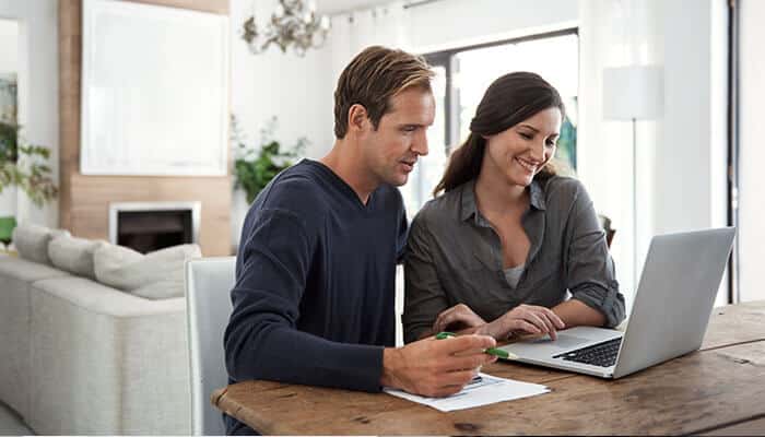 Couple signing up on a laptop and discussing signup mistakes on popular apps such as incorrect personal details or verification issues during the process.