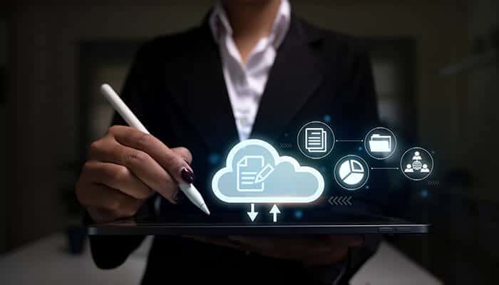 Business professional using a digital tablet with cloud icons, showcasing the power of online faxing software and secure document transmission