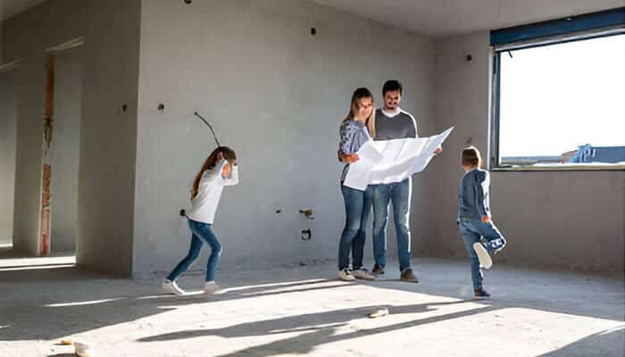 A family reviewing renovation plans inside an unfinished home, representing home upgrade planning for families preparing for a major remodel.