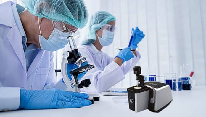 Researchers working in a laboratory using microscopes and testing samples, with Agilent FTIR spectroscopy instruments shown in the foreground to highlight their role in advanced scientific analysis