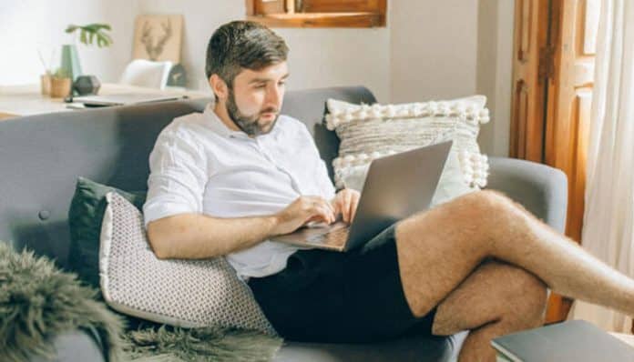 Man working remotely on a laptop at home, representing remote work monitoring for startups.